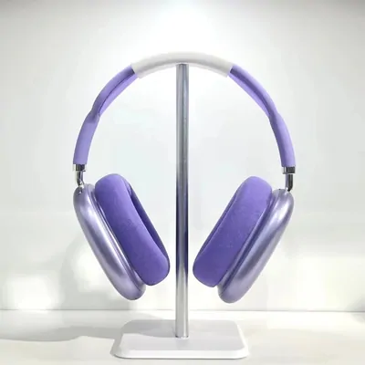 Purple over-ear headphones on a metal stand against a pale grey background
