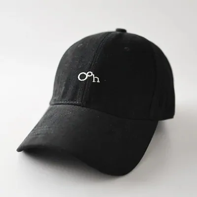 A black baseball cap with a small white embroidered logo on the front panel