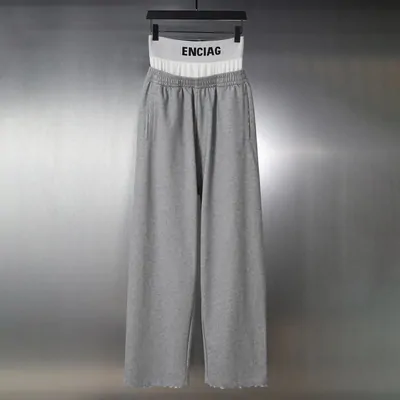 Grey wide-leg sweatpants with a white elastic waistband on a rail